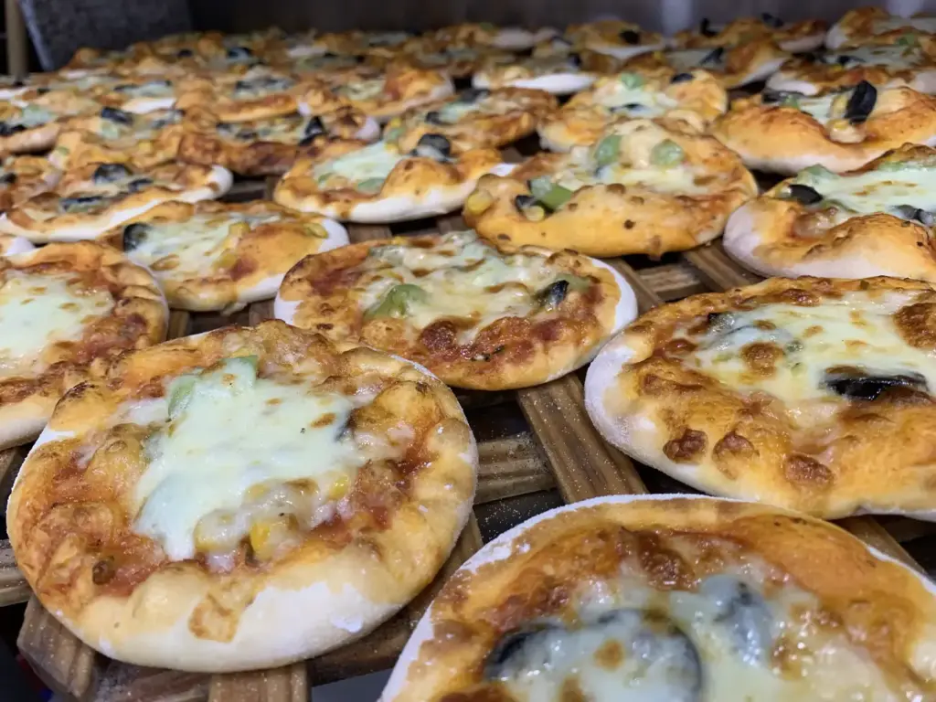 Manakish mit geschmolzenem Käse auf einem Holzrost