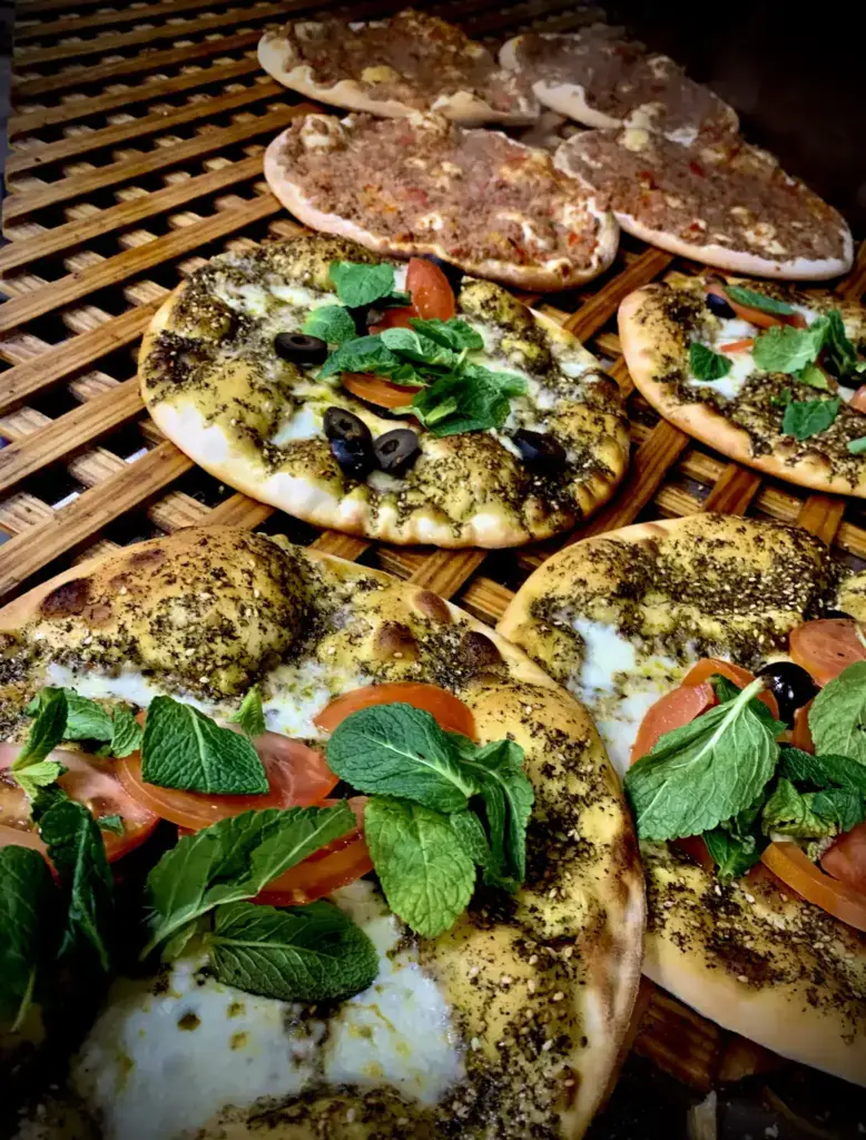 Manakish mit Zaatar Frisch gebackene Manakish mit Zaatar, Tomate und Minze